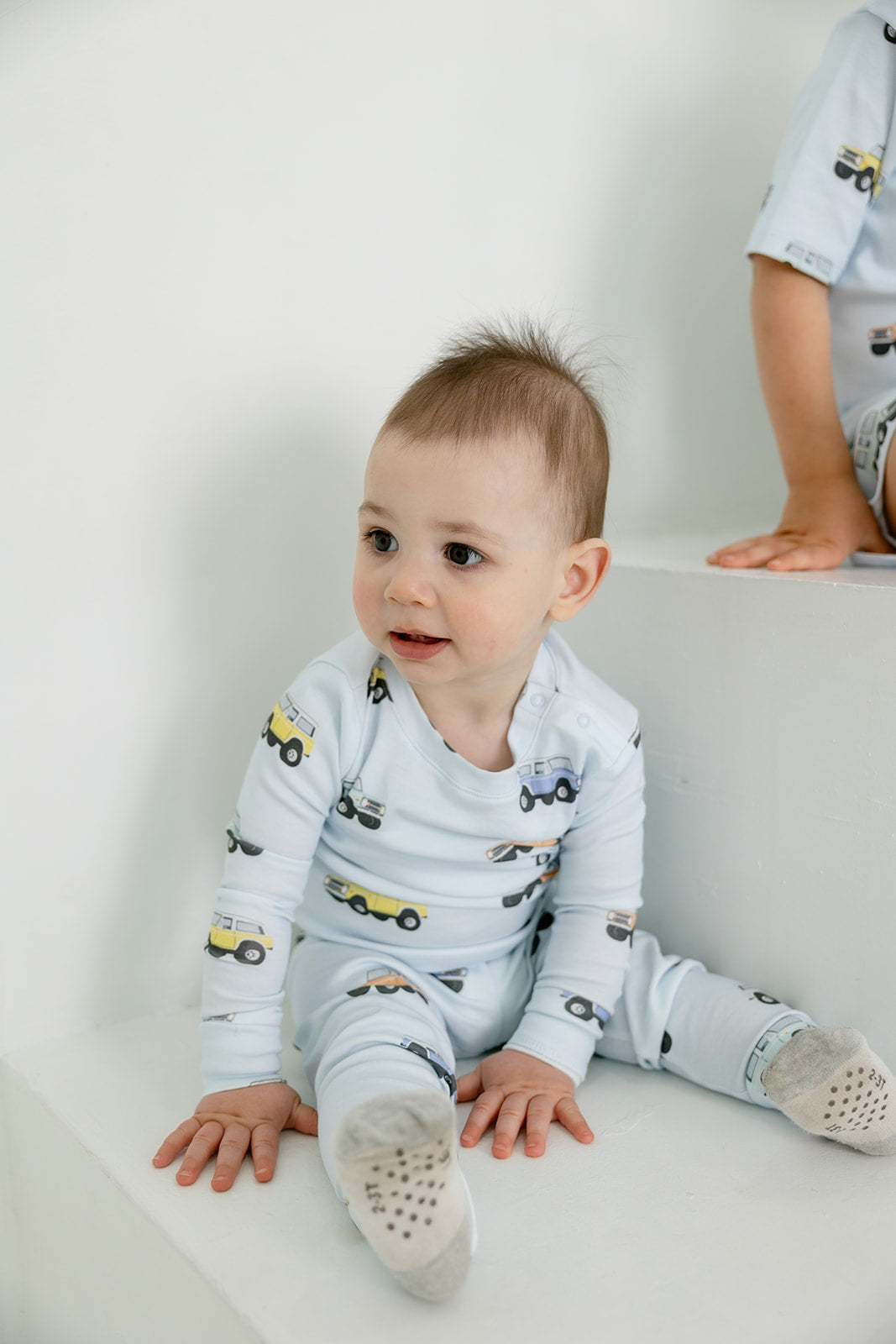 Baby wearing Bianca & Bear Bronco Pima cotton sleeper with matching sibling style